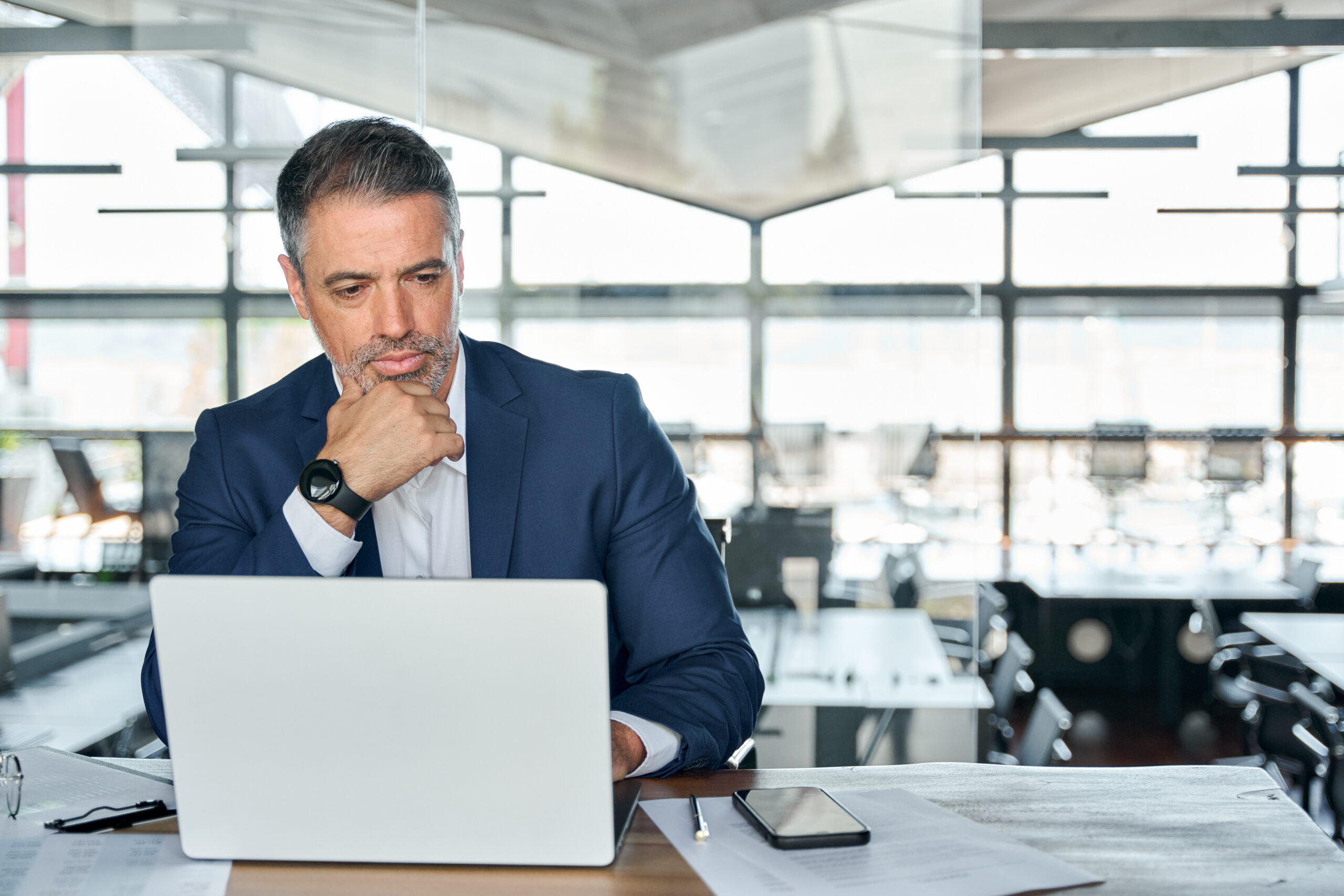 Serious Mature Business Man Executive Sitting At Desk Using Laptop. - Regulariza Portal